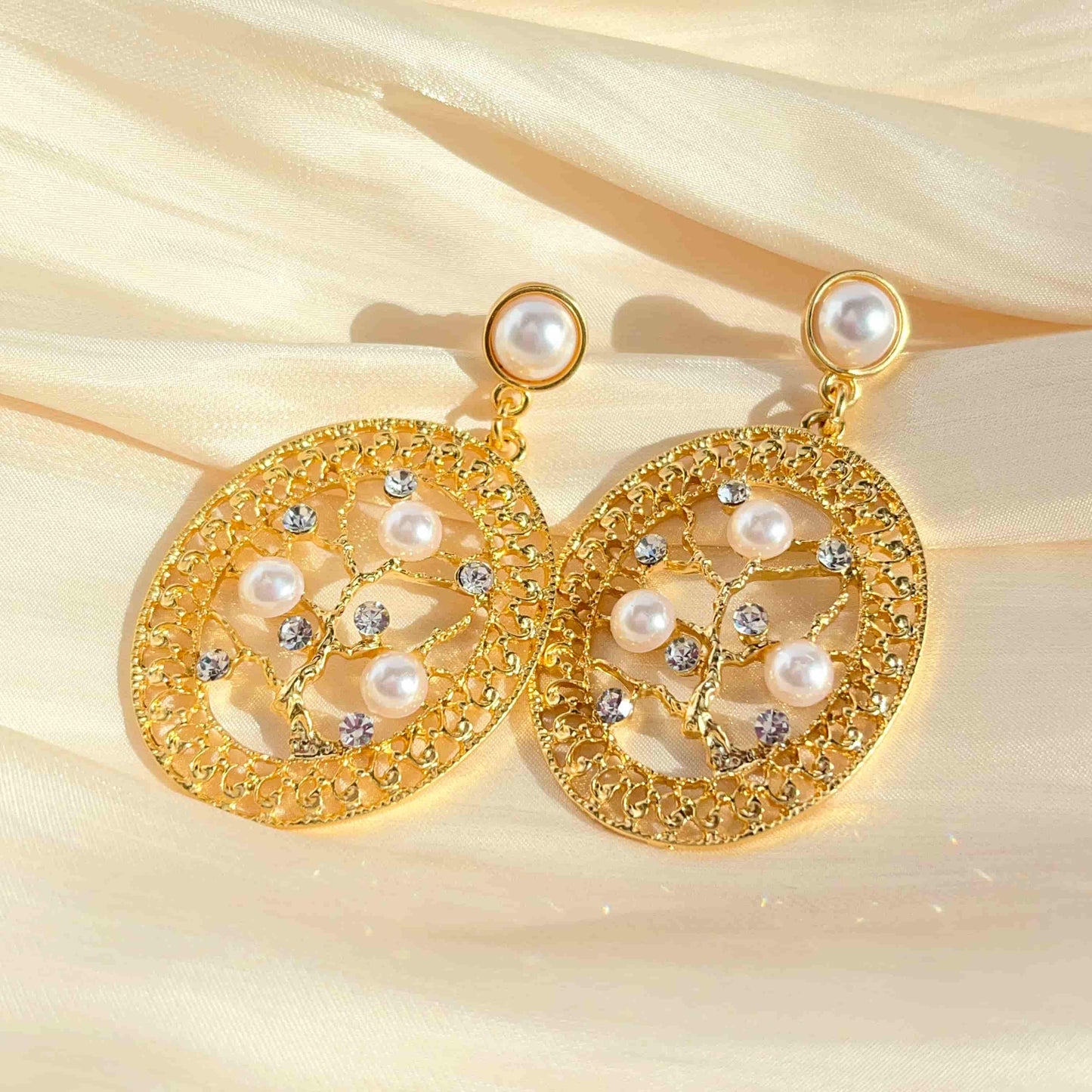 Unique Oval Filigree Branch Earrings, Adorned with Zirconia and Mother of Pearl Material:S925 silver pins copper plated with 18K gold, Mother of pearl, Zircon Weight:13.1g / pair Dimensions:6cm*3.5cm