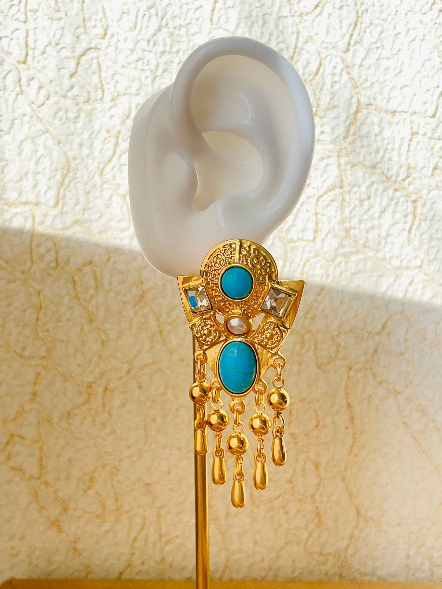 Exquisite Gold Clip-on Pendant Earrings adorned with Turquoise, Zircon, and Mother of Pearl. Material:Copper plated with 18K gold, Turquoise, Mother of pearl, Zircon Weight:37.4g / pair Dimensions:7cm*3.2cm