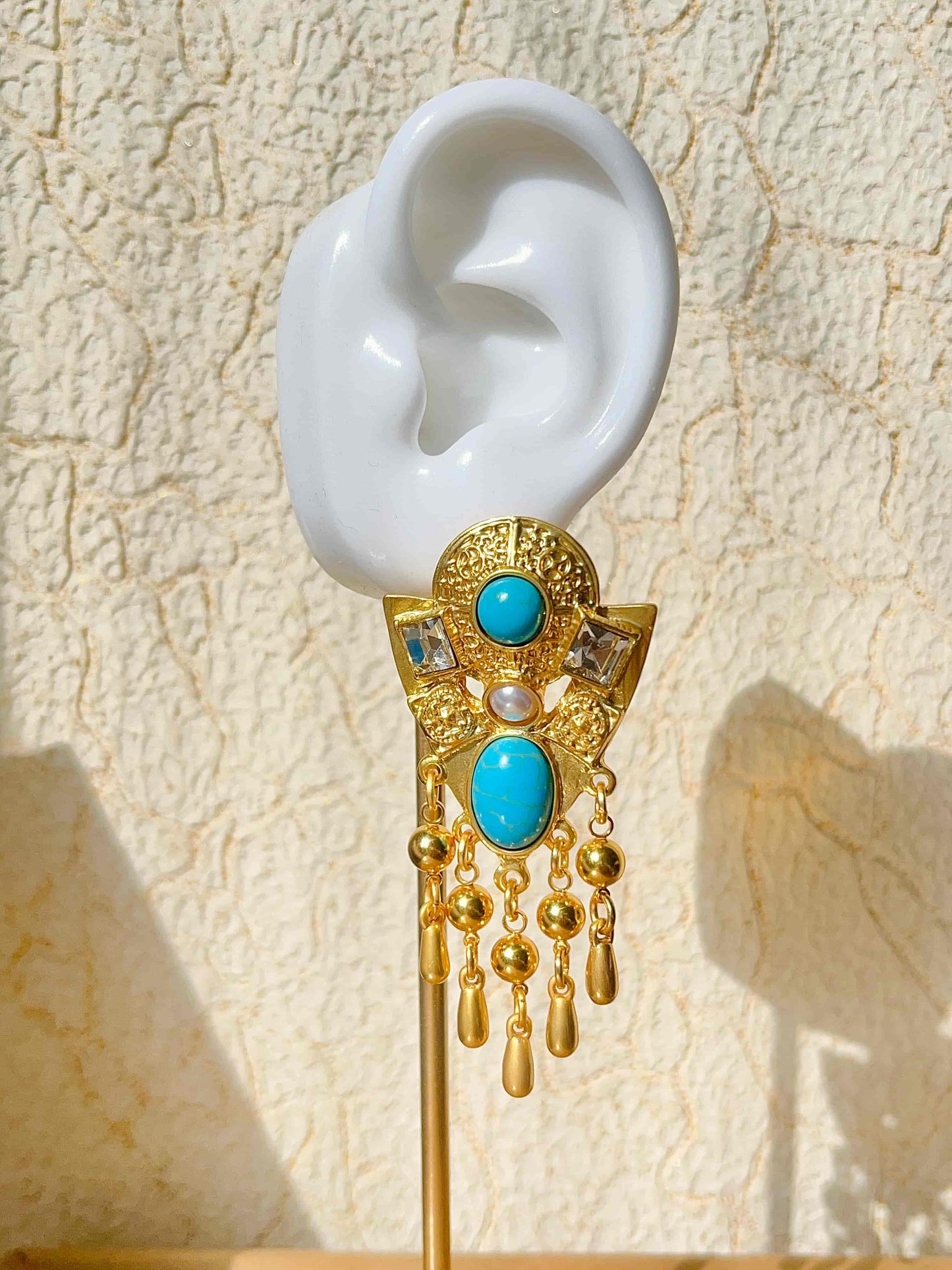 Exquisite Gold Clip-on Pendant Earrings adorned with Turquoise, Zircon, and Mother of Pearl. Material:Copper plated with 18K gold, Turquoise, Mother of pearl, Zircon Weight:37.4g / pair Dimensions:7cm*3.2cm