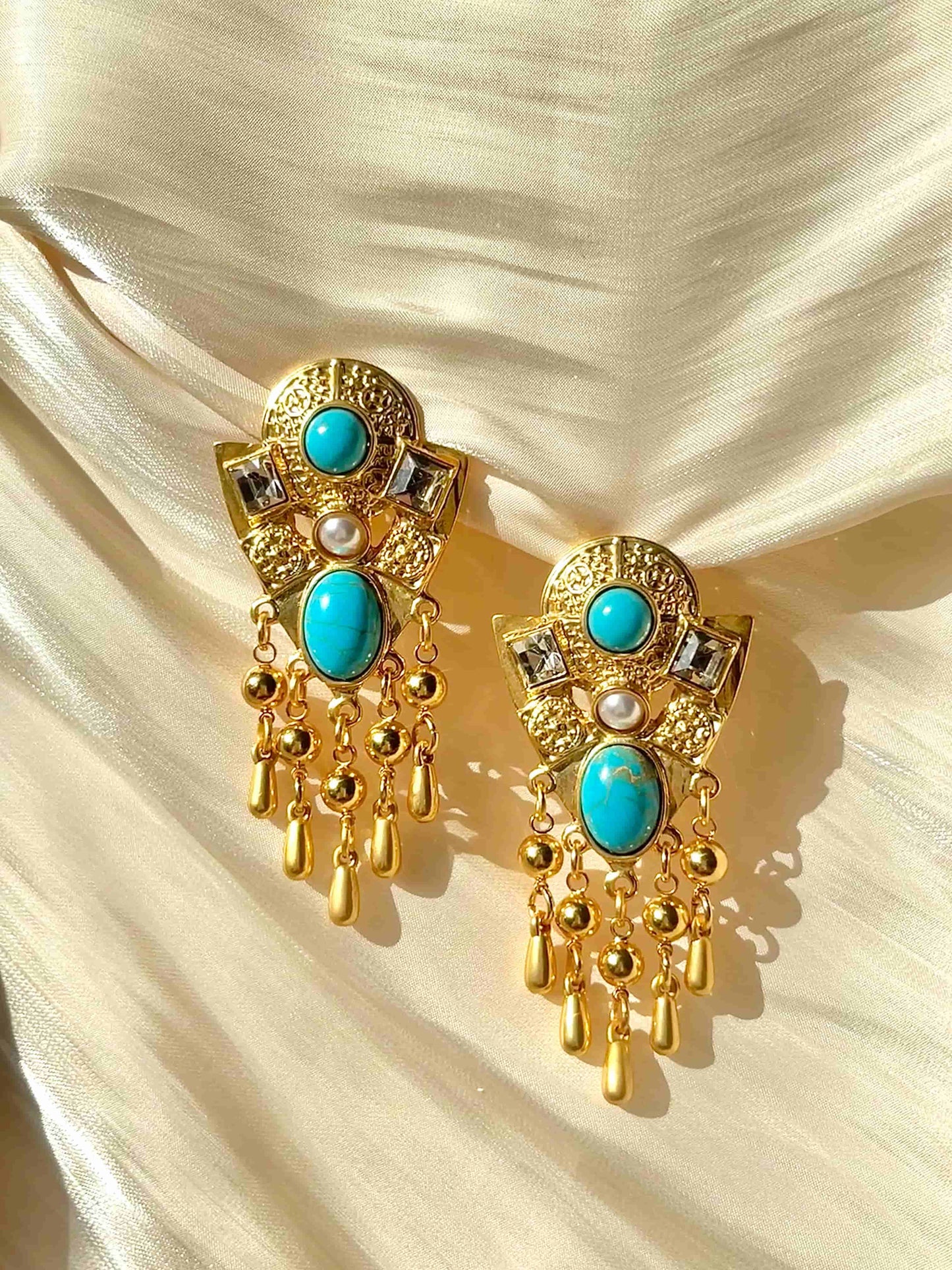 Exquisite Gold Clip-on Pendant Earrings adorned with Turquoise, Zircon, and Mother of Pearl. Material:Copper plated with 18K gold, Turquoise, Mother of pearl, Zircon Weight:37.4g / pair Dimensions:7cm*3.2cm