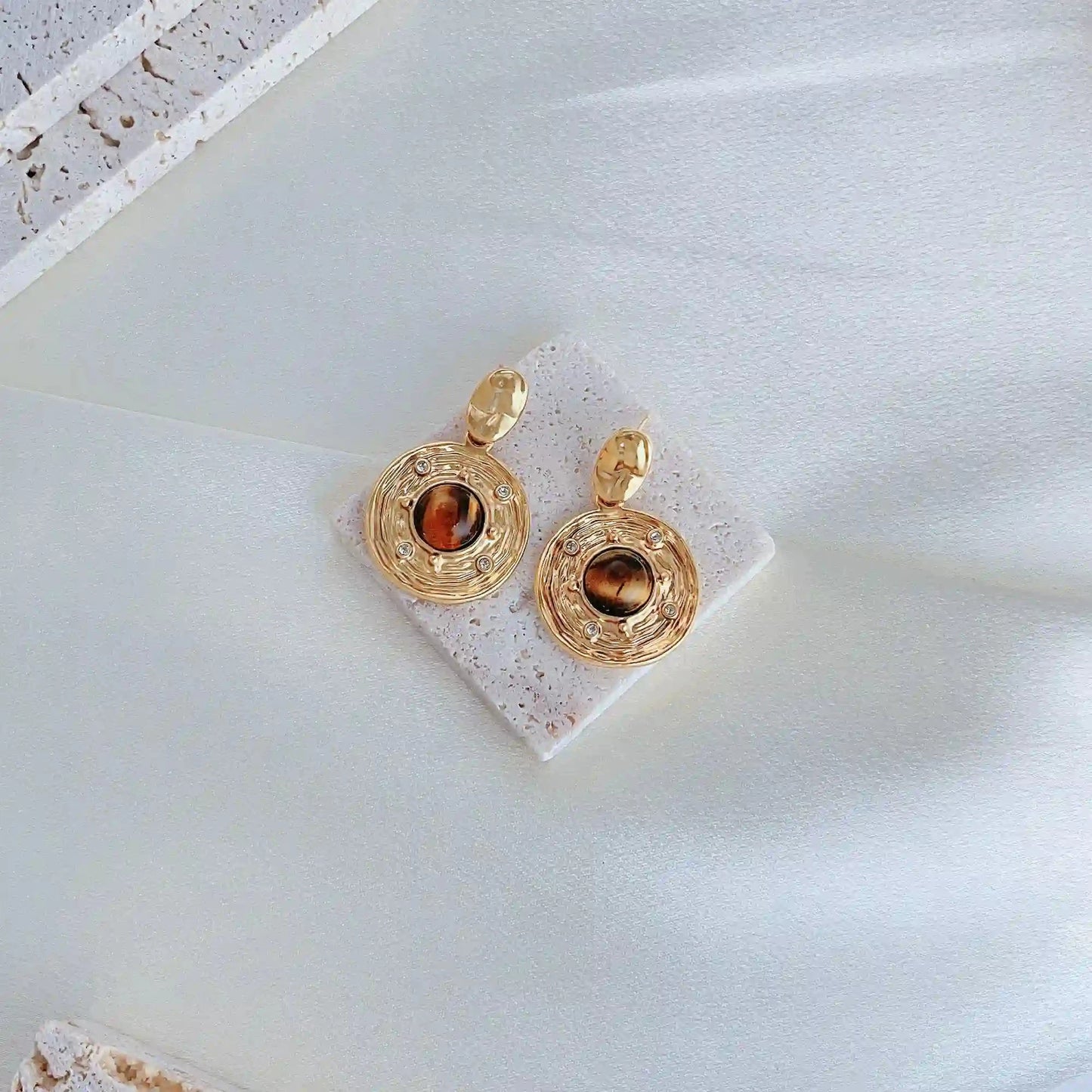 A Feng Shui Tiger-eye stone jewelry for you. The tiger-eye is known as the stone of self-confidence! Material: S925 silver pins, tigerite and copper plated with 18K gold, zircon Weight: 15.4g/pair Dimensions:3.9cm*2.5cm